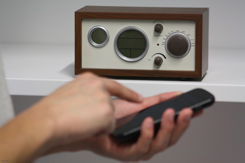 Un usuario utiliza un móvil junto a un viejo aparato de radio.