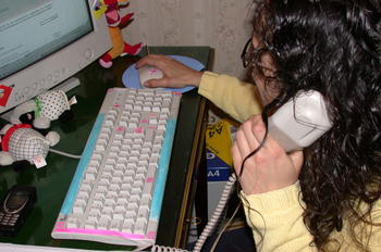 Un usuario utiliza su ordenador mientras habla por teléfono.