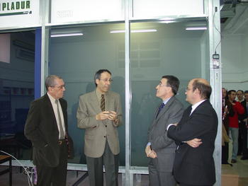 El rector posa con los autores del proyecto ante la cabina de simulación