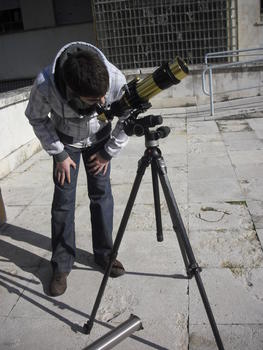 Un estudiante observa el sol a través del telescopio.