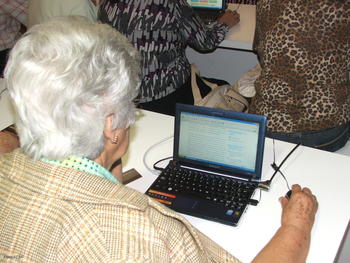 Una persona mayor navega en internet en un ordenador portátil.