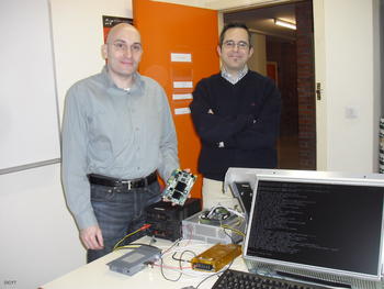 Los investigadores Diego Llanos y Arturo González, quien sostiene uno de los sistemas empotrados que han desarrollado.