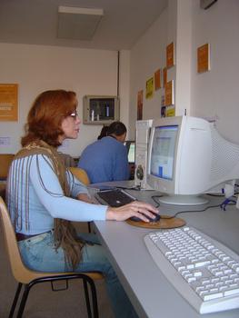 Una mujer accede a Internet desde un telecentro