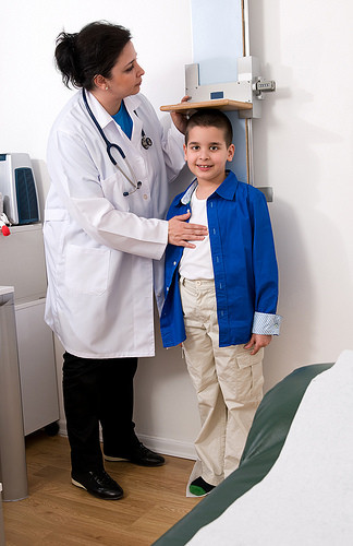 Una doctora mide la talla de un niño. 