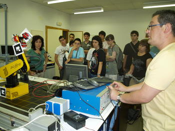 Un profesor de Informática muestra a los jóvenes uno de los robots del departamento.