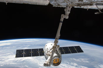 Arriba: Acople de la cápsula Space X a la Estación Espacial Internacional. Crédito: NASA.