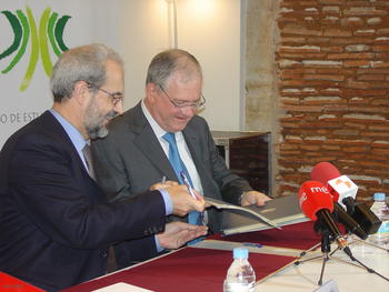 Daniel Hernández Ruipérez y Marco Antonio Zago intercambian los documentos firmados.