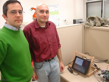 Los investigadores Diego Llanos (izq), y Arturo González, junto al dispositivo diseñado para los trenes. 