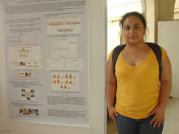La investigadora Alexandra Plata y el póster de su comunicación científica.
