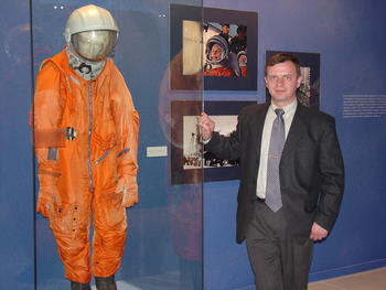 El astronauta posa con uno de los trajes utilizados en misiones al espacio