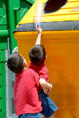 Dos niños arrojan envases al contenedor amarillo.
