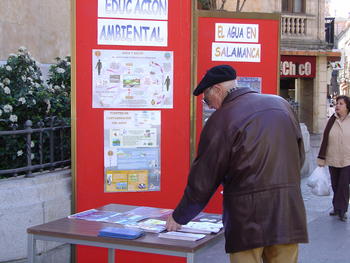 Un ciudadano recoge folletos de la exposición sobre el agua