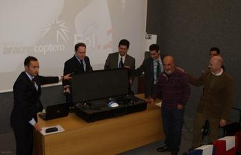 Los representantes de las empresas colaboradoras de Arbórea abren la caja donde se guarda el 'aracnocóptero'.