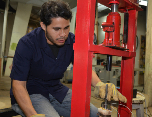El estudiante Tony Carrillo Paniagua, quien actualmente realiza su tesis licenciatura en Ingeniería Agrícola, muestra el proceso de fabricación de los “pellets”. FOTO: UCR.