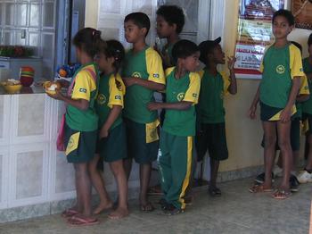 Niños con uniforme escolar hacen cola para almorzar en Escola Bona Espero, Alto Paraíso de Goiás, Brasil.