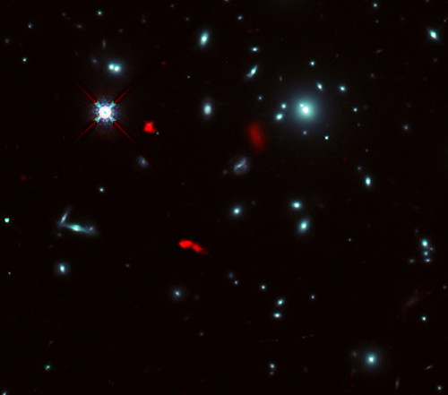 Imagen del cúmulo de galaxias RXCJ0600-2007 tomada por el telescopio espacial Hubble de la NASA/ESA combinada con imágenes de lente gravitacional de la lejana galaxia RXCJ0600-z6, obtenidas con ALMA/ALMA (ESO/NAOJ/NRAO)