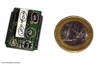 Chip que emplea el protocolo Zigbee, con sus secciones numeradas, junto a una moneda de un euro que sirve como escala.