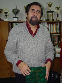 El profesor Ernesto Zumelzu con su tesis doctoral en la mano