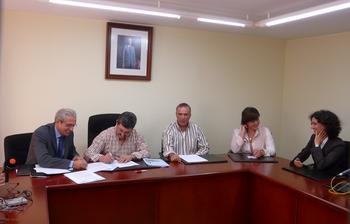 José Angel Azuara (izq.) firma el convenio de colaboración con los alcaldes de Cabañas Raras y de Cortiguera.
