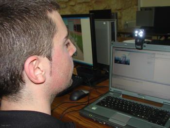 Uno de los alumnos ensaya en el ordenador y con webcam el programa que capta los movimientos de la cabeza.