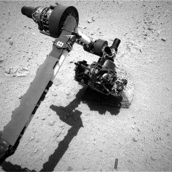 El brazo robótico de Curiosity estudiando una roca marciana.