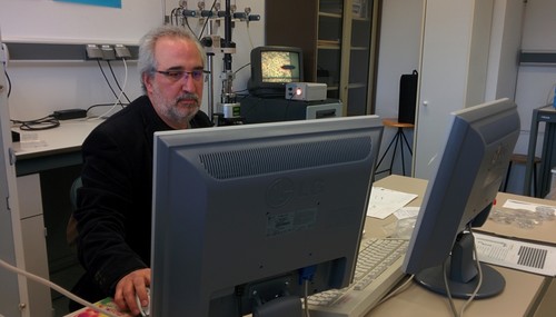 El catedrático Pedro Prádanos observa en la pantalla una muestra a través de un microscopio de fuerza atómica (a sus espaldas)/UVa